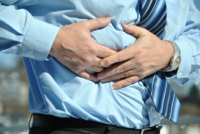 Mann hält sich den Bauch vor Schmerzen