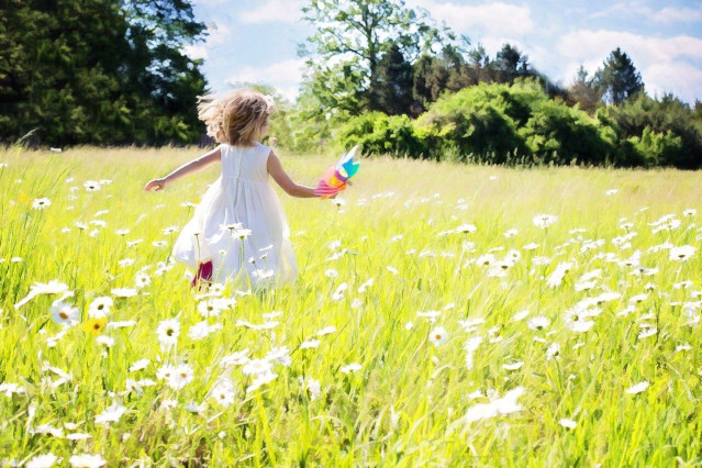 Blumenwiese auf dem ein ausgeglichenes Kind spielt