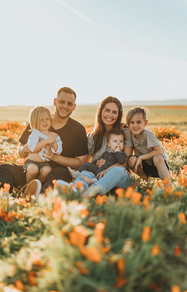 Familie auf einem Blumenfeld im Sonnenlicht